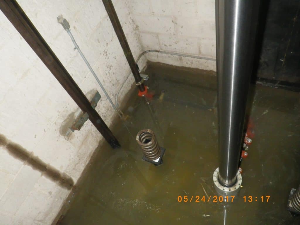 Flooded elevator pit in need of elevator pit waterproofing.